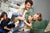 Man and his son play in the foreground with a woman and her child playing in the background in the living room.